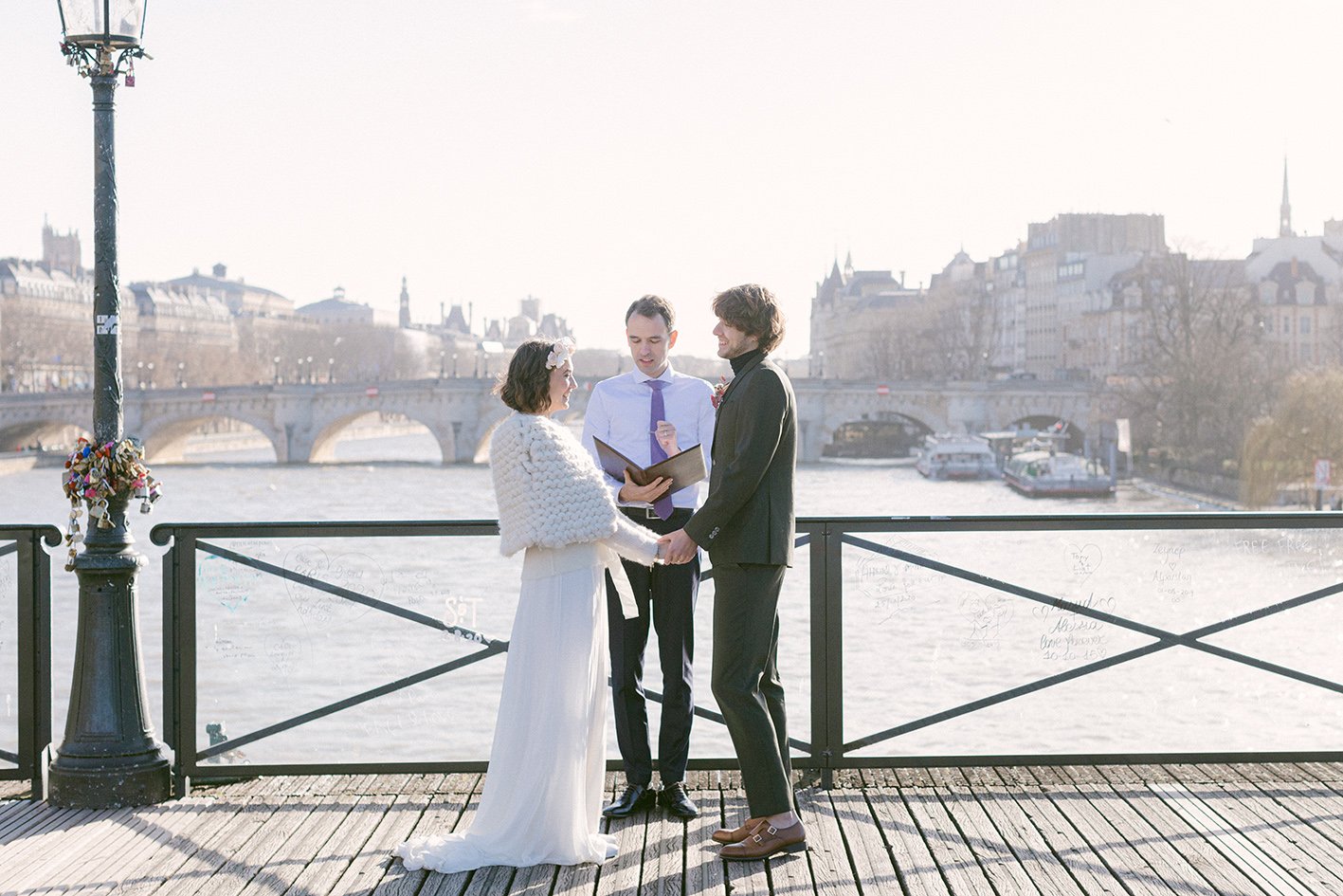 A couple is eloping on a famous bridge of Paris, with officiant Jean-Sébastien